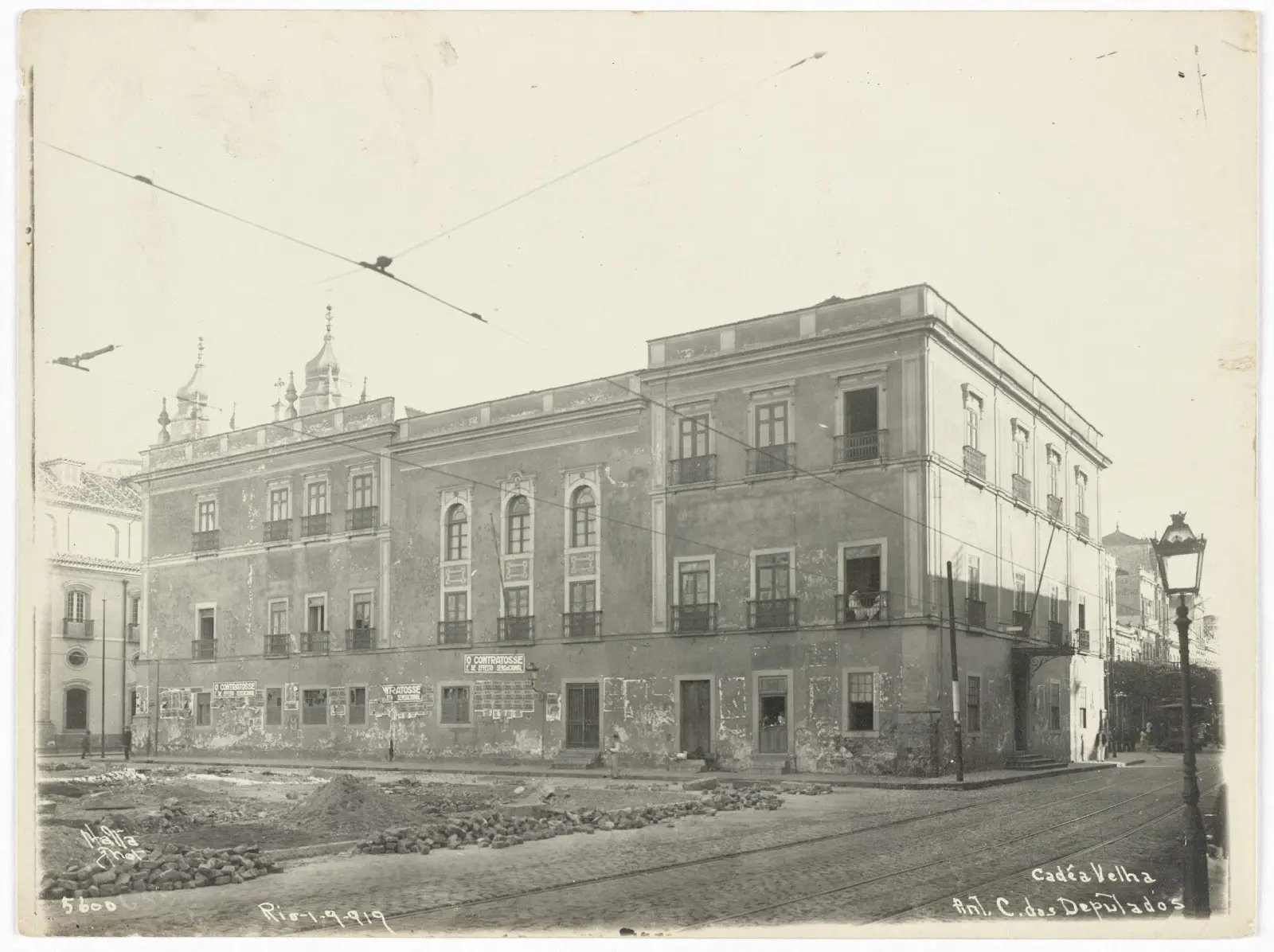 Palácio histórico em preto e branco, com edifícios e inscrições.