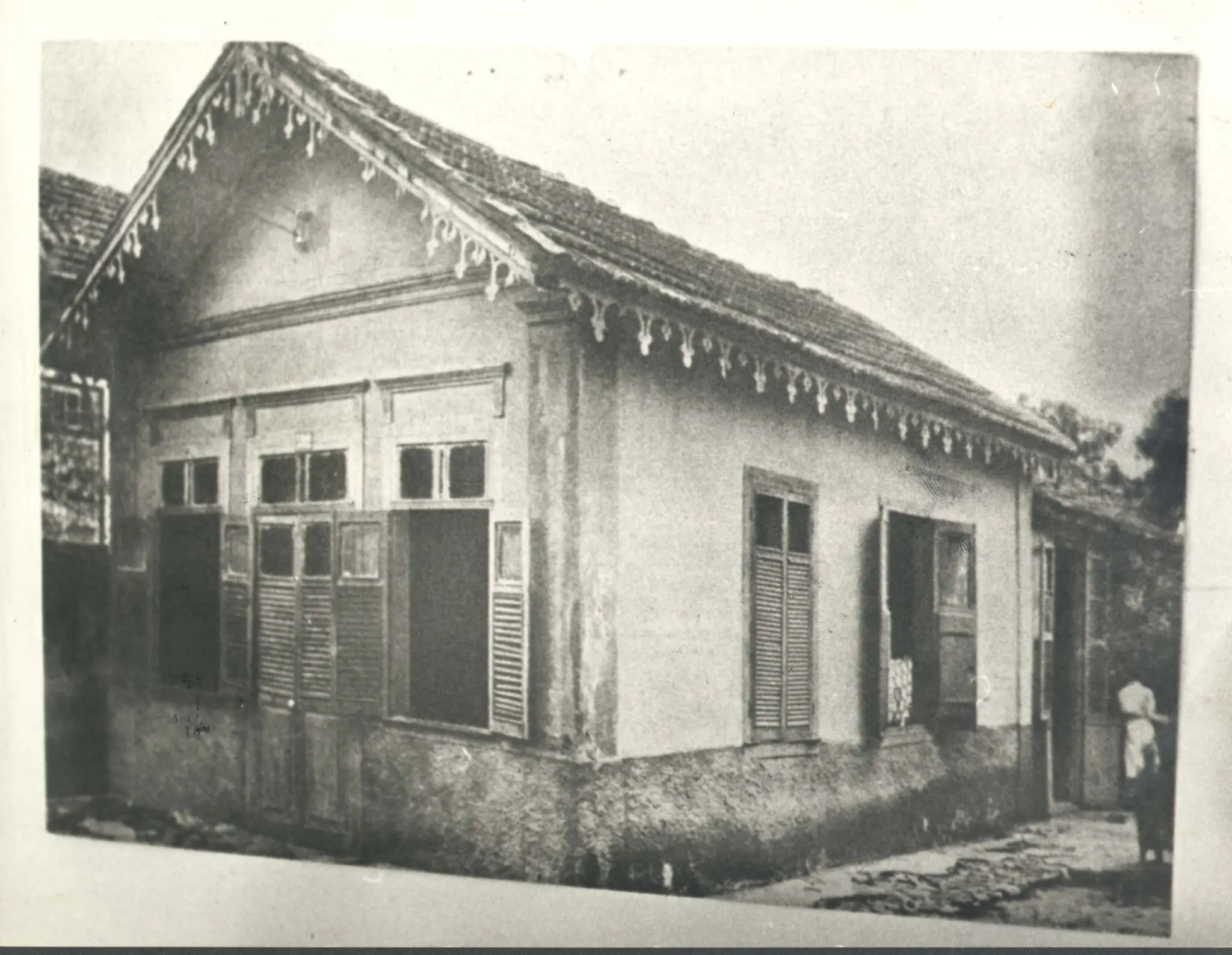 Edifício antigo com detalhes decorativos e persianas fechadas.