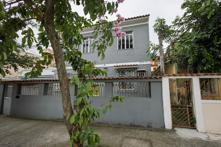 Casa residencial com telhado vermelho e cerca branca.