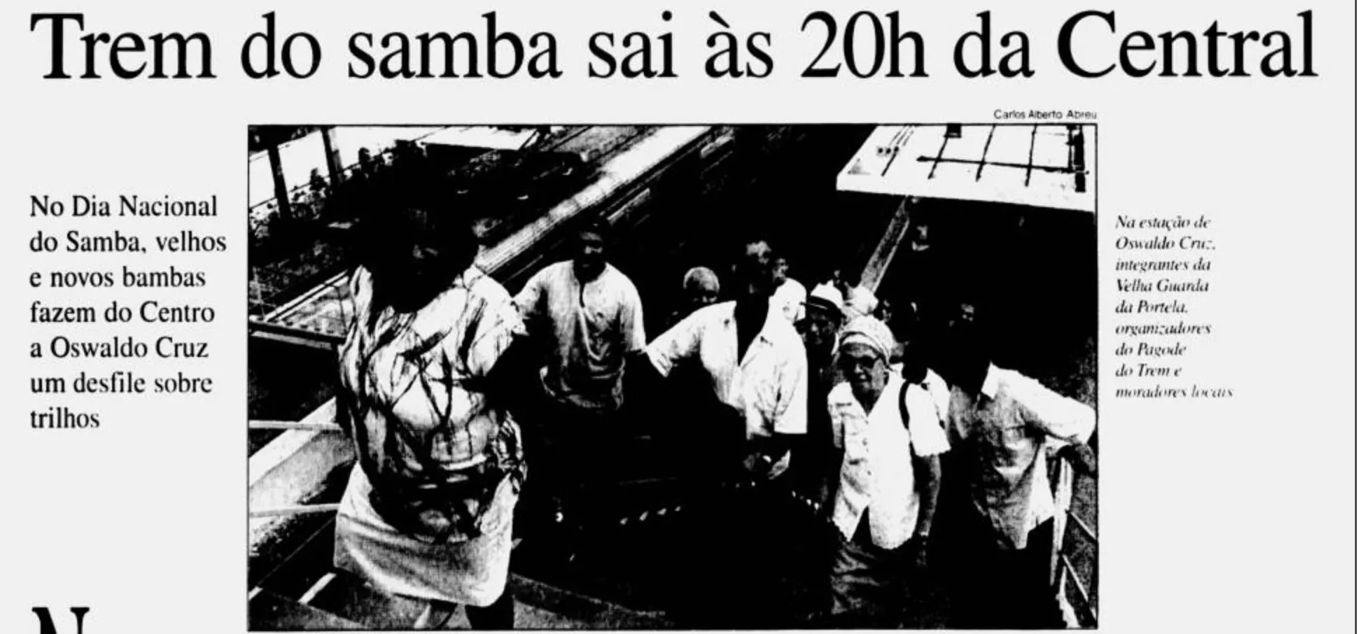 Fotografia preto e branco de pessoas caminhando em uma plataforma de trem.