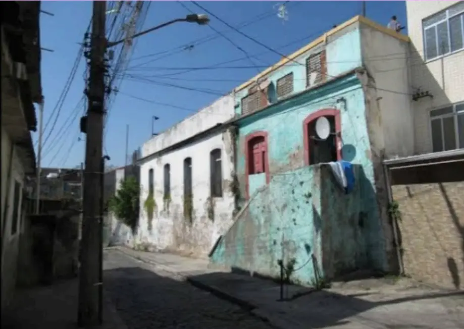 Uma rua residencial com construção antiga e céu azul.