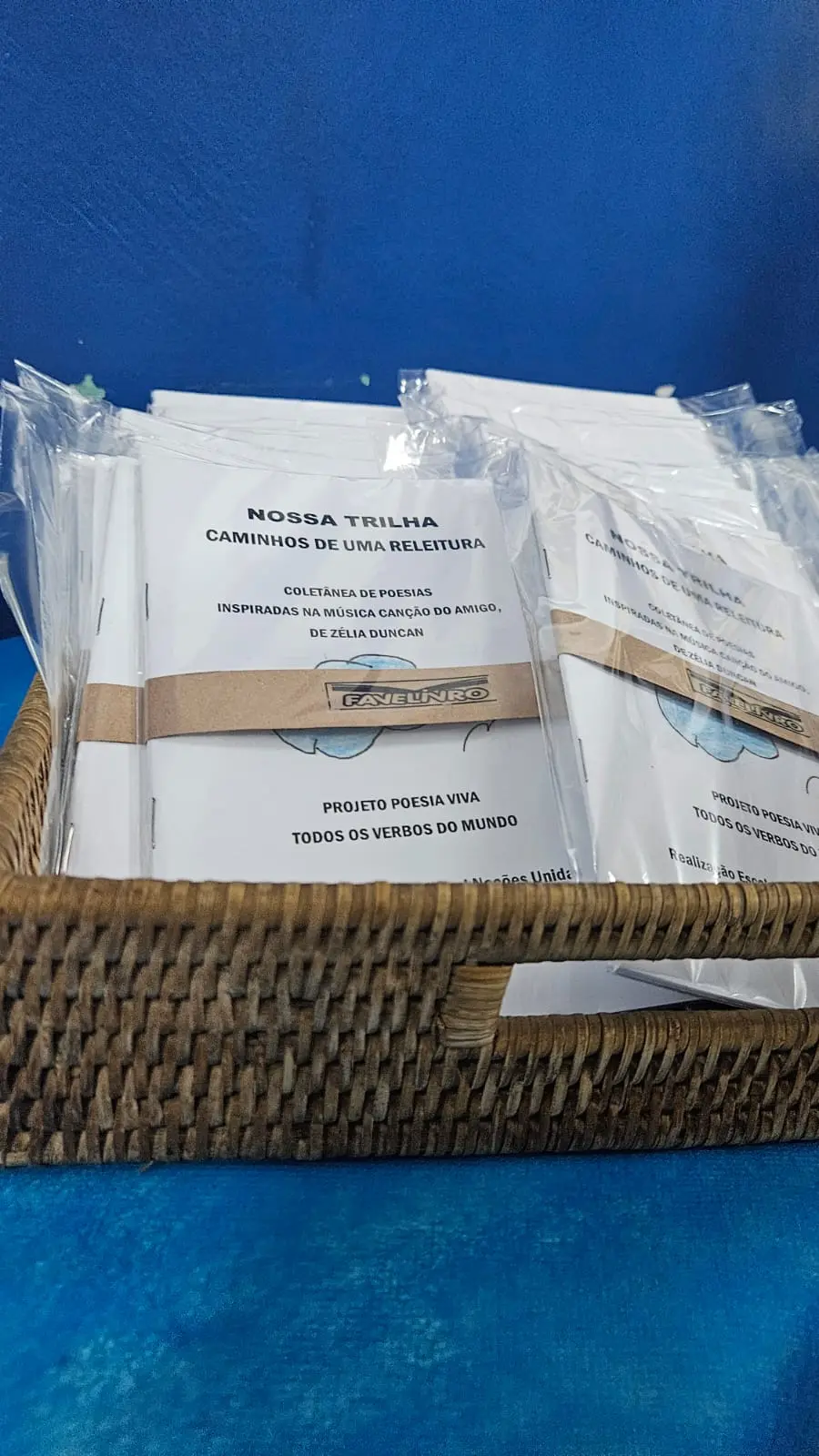 Cesto de vime com pacotes de folhas de papel em azul.