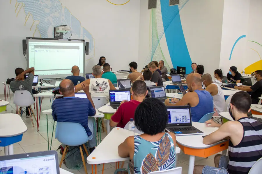 Sala de aula com apresentação projetada e alunos participando ativamente.