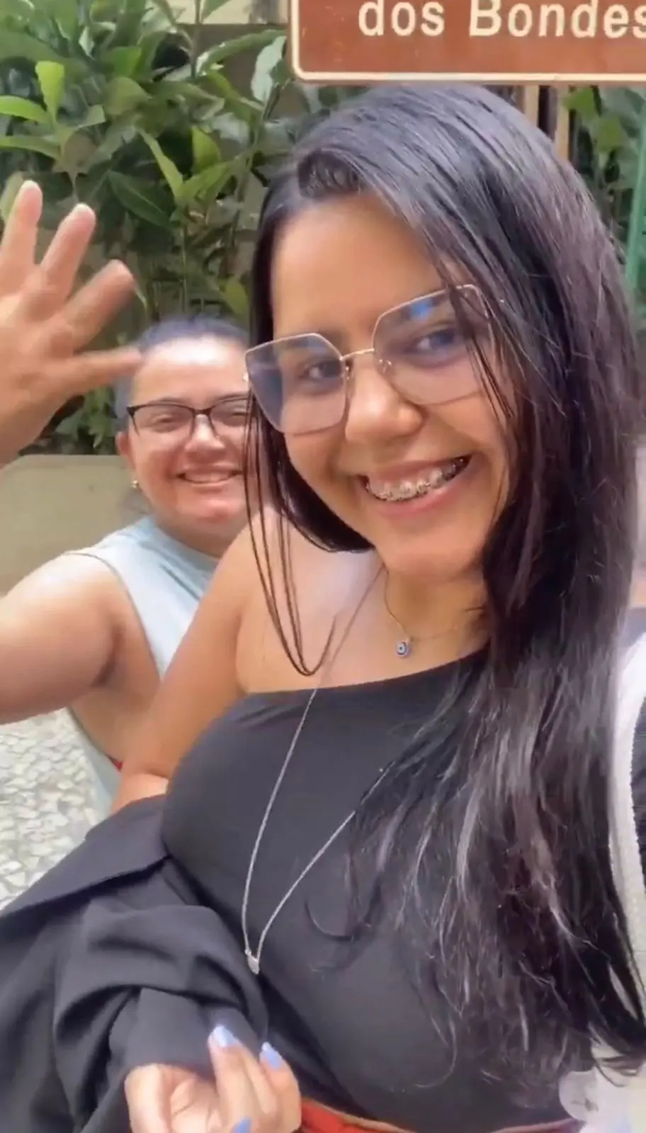 Duas pessoas sorridentes em ambiente verde.