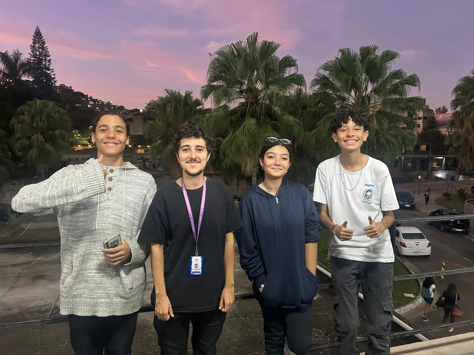 Quatro amigos sorridentes ao entardecer em um parque.