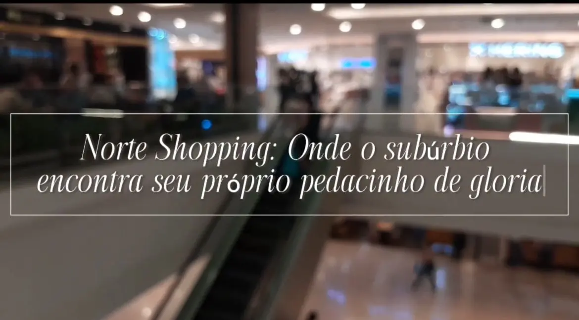 Shopping center com escada rolante e lojas iluminadas.