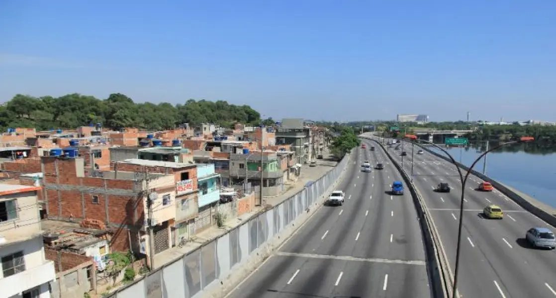 Área urbana com estrada duplicada e edifícios residenciais.
