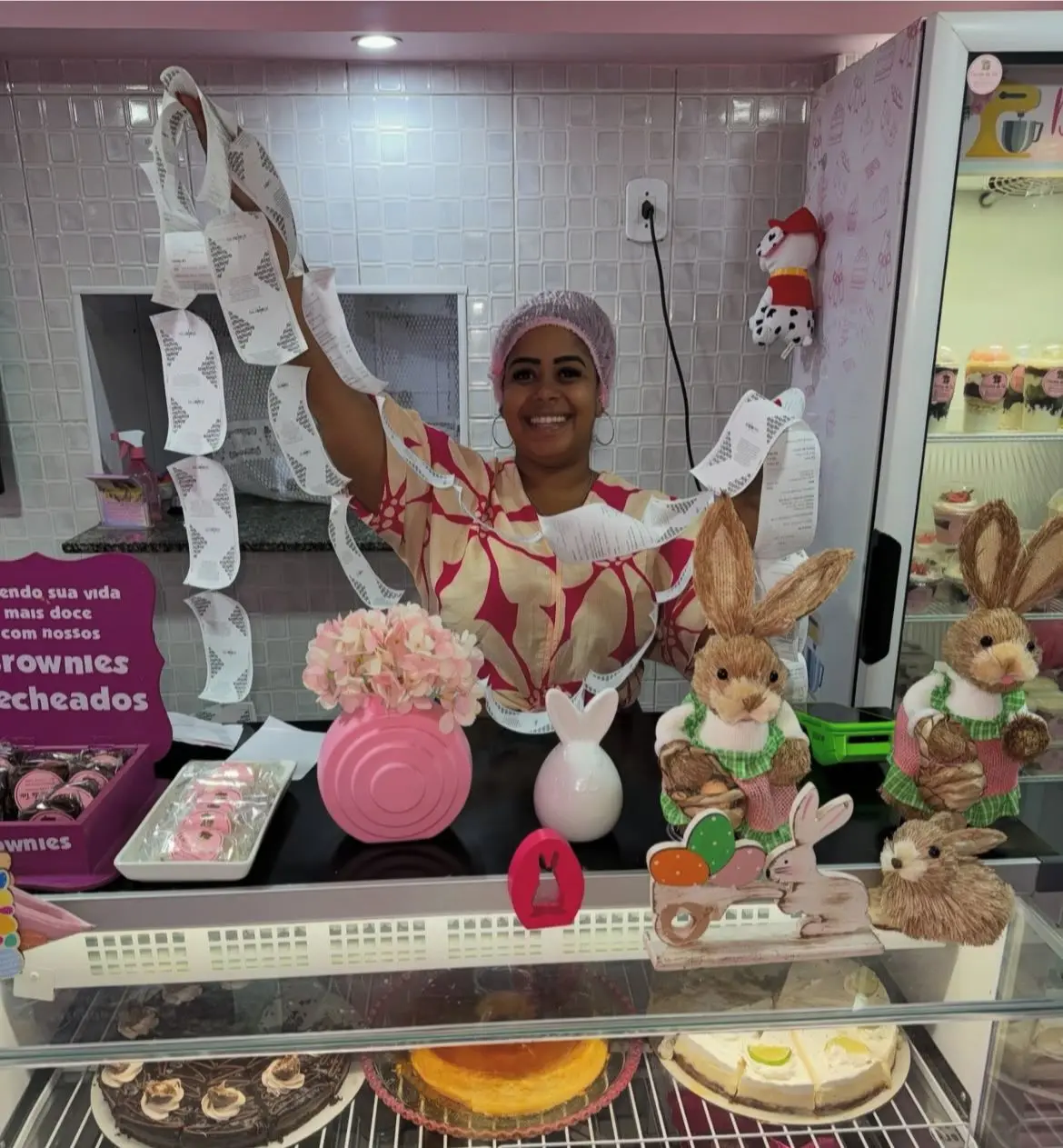 Fotografia de doceria "Doceria da Teté" com mulher levantando papel higiênico.