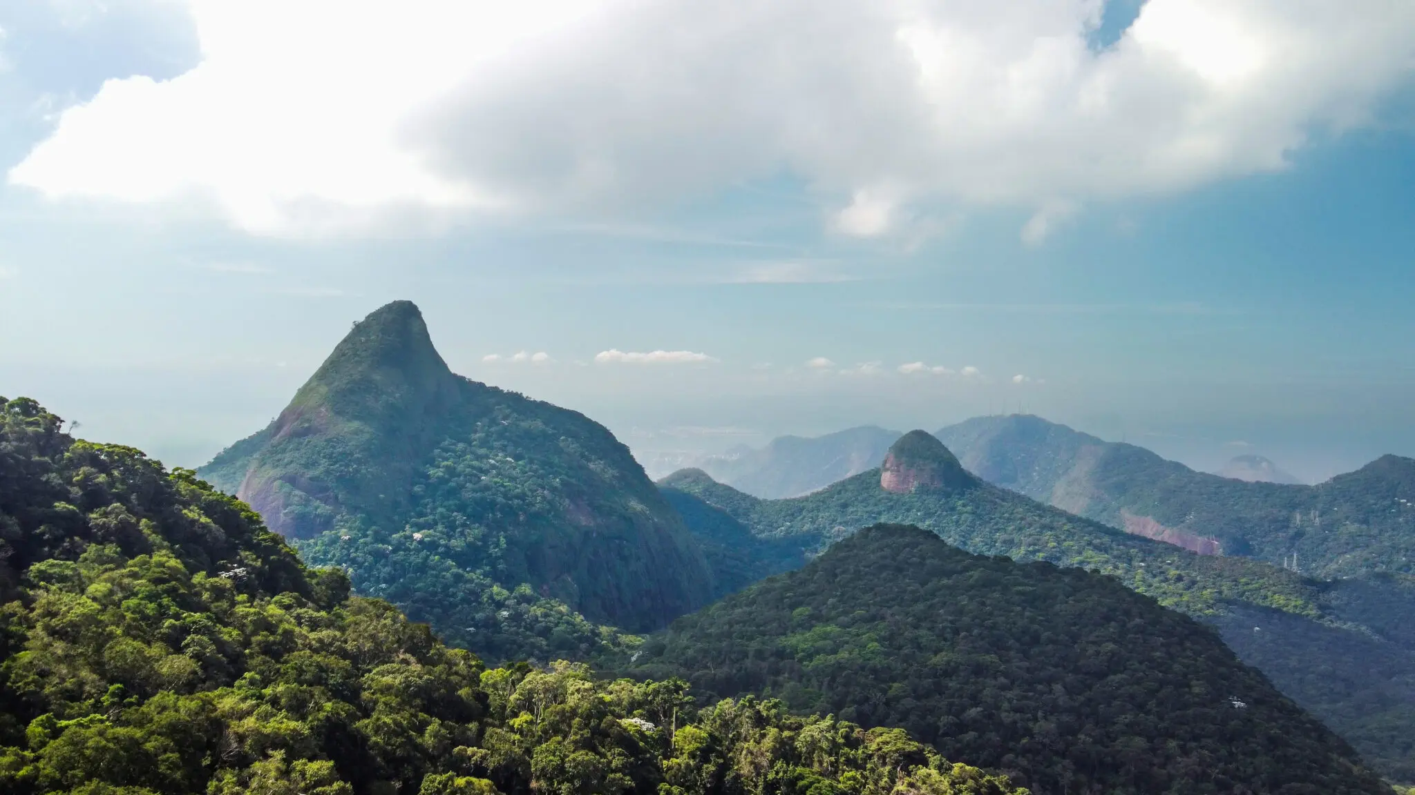 Montanhas verdes em um cenário montanhoso sob céu azul.