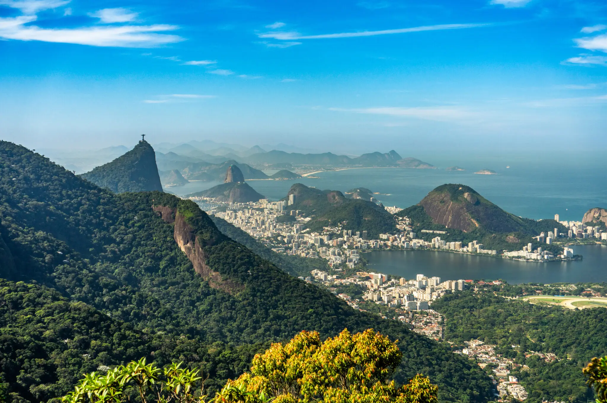 Paisagem urbana com montanhas e mar ao fundo.