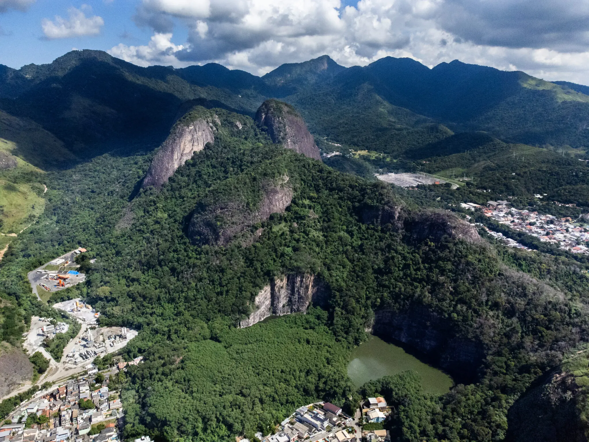 Maciço montanhoso com vegetação verde, construções e aldeia.