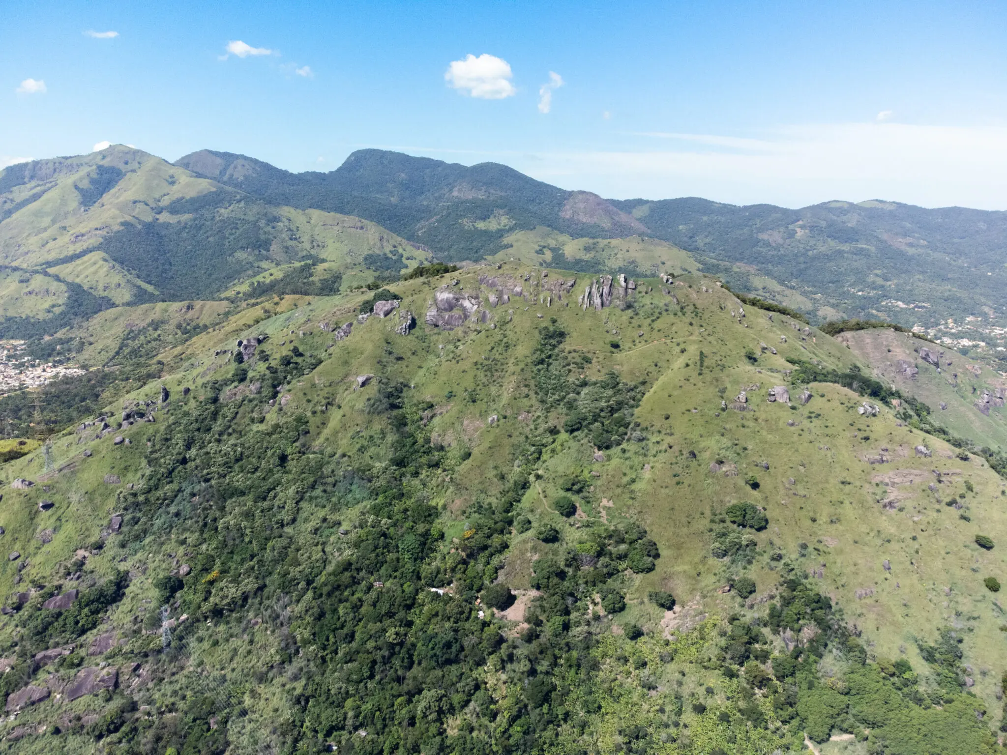 Maciço montanhoso sob céu azul, paisagem extensa e majestosa.