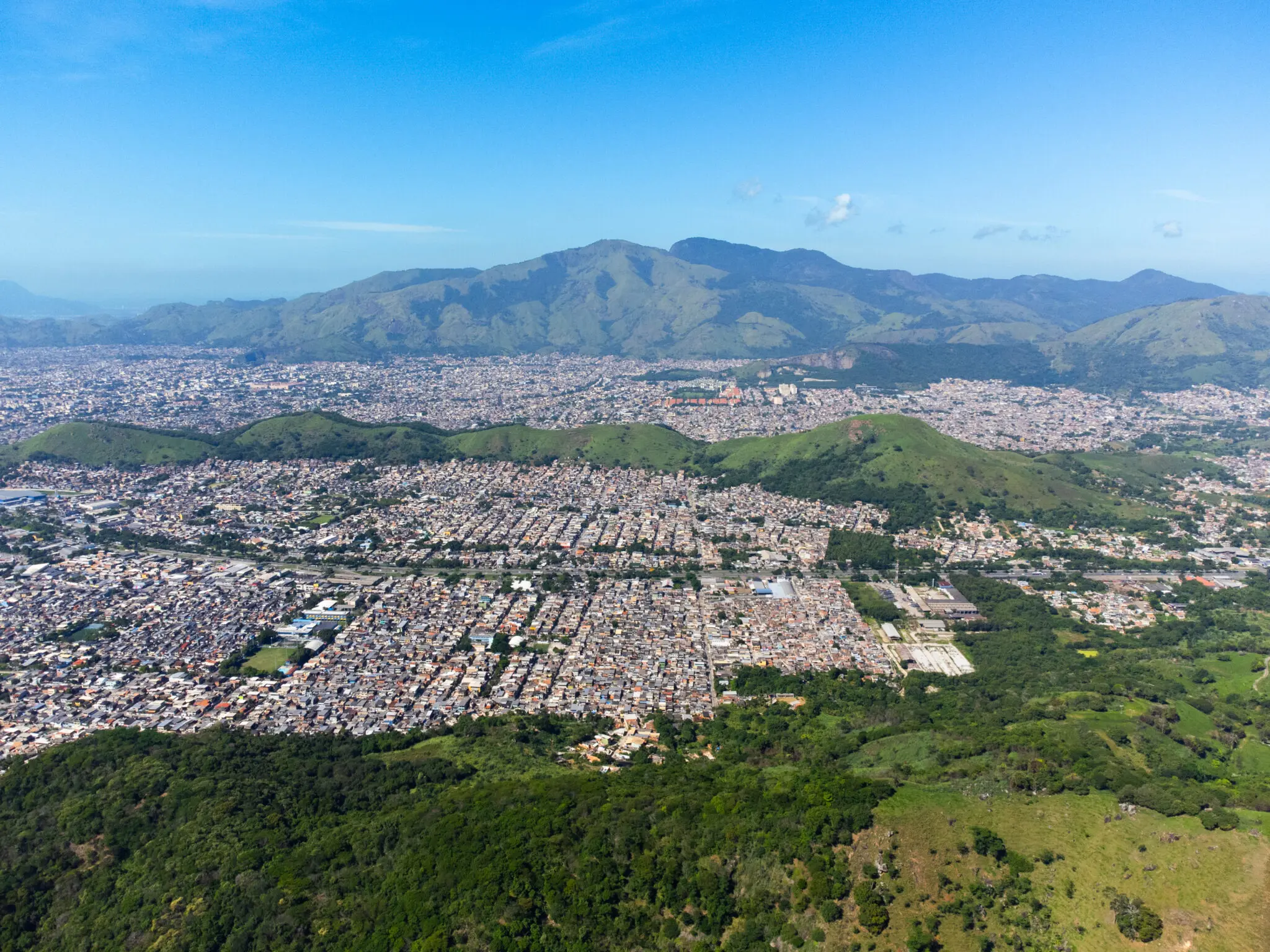 Cidade urbana rodeada por montanhas verdes.