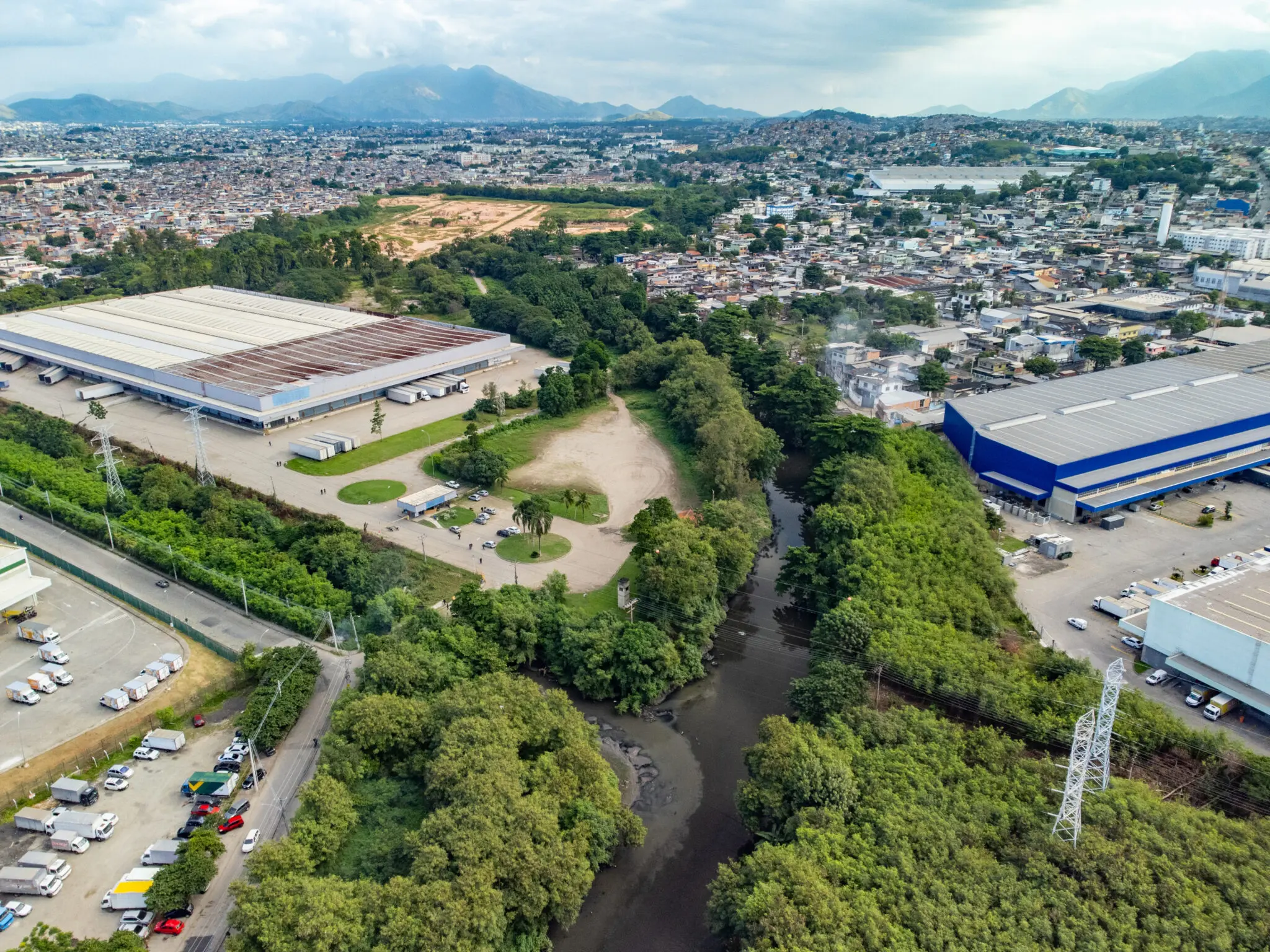 Fotografia aérea de área urbana com fábricas e áreas verdes.