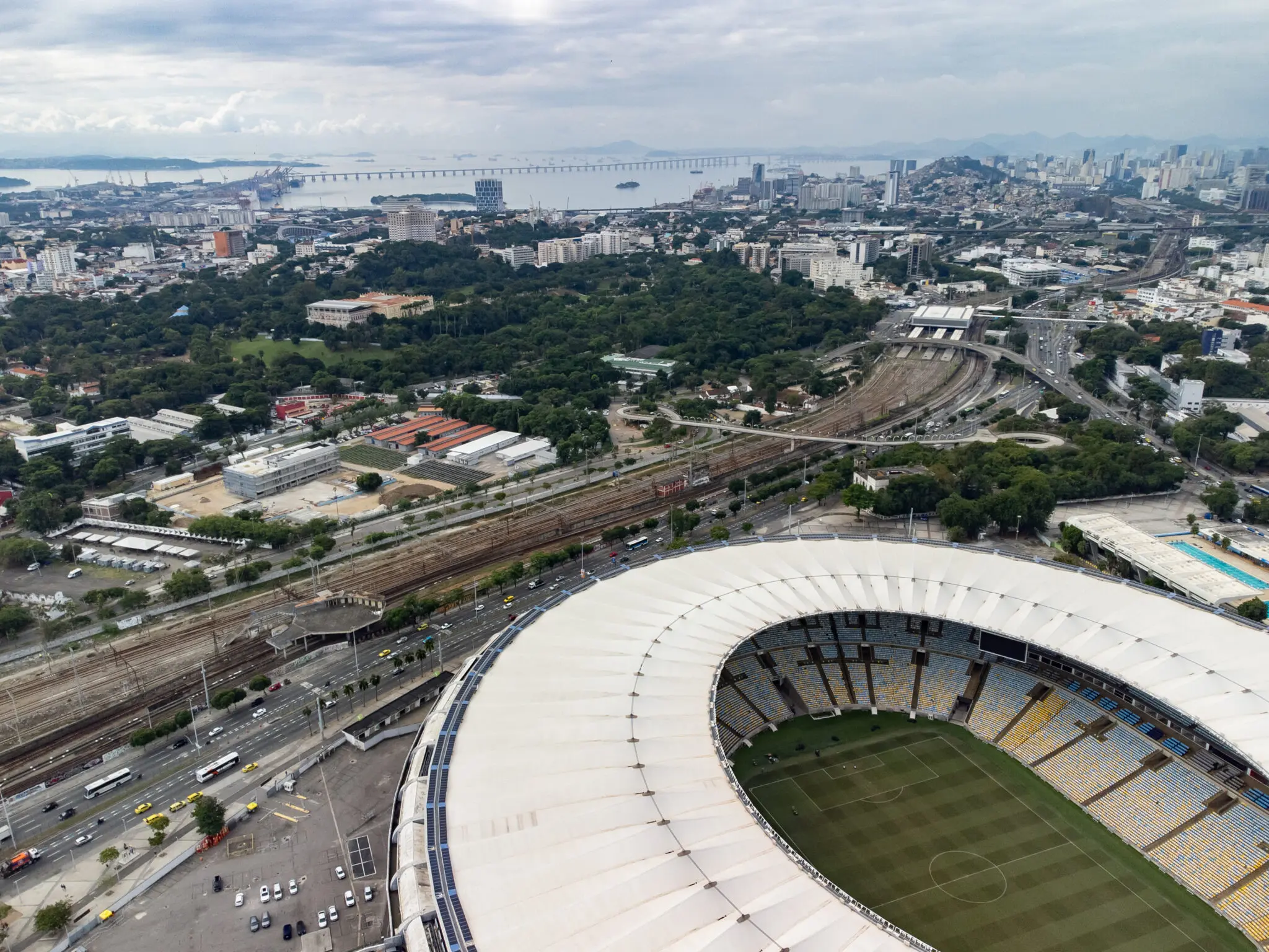 Estádio de futebol em cidade costeira com arquitetura moderna.