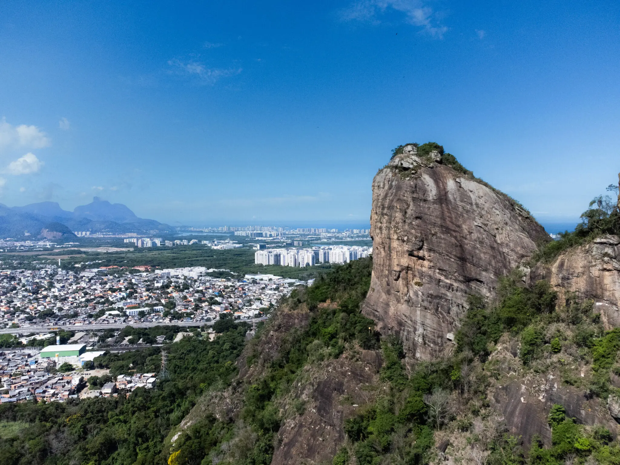 Paisagem urbana com montanhas e vegetação.