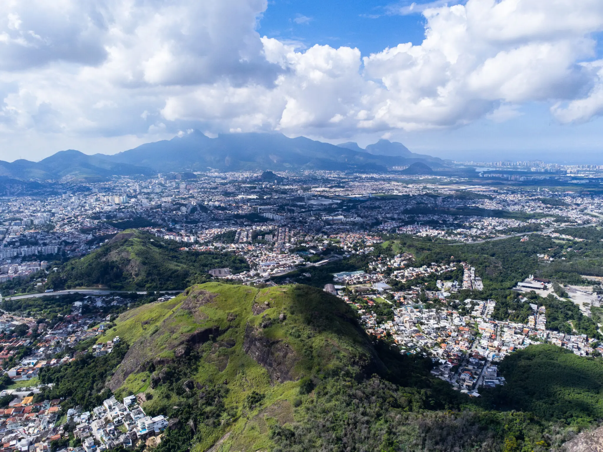 Cidade com edifícios e montanhas ao fundo.