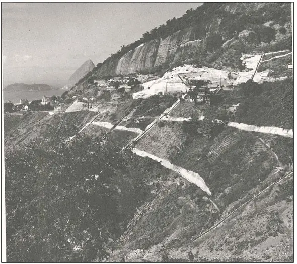 Paisagem montanhosa com estrada e rocha escarpada.