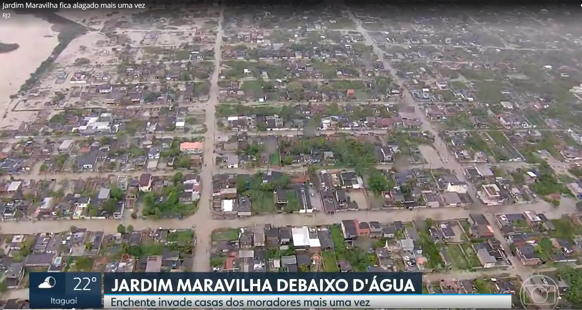 Área residencial alagada com casas e ruas inundadas.