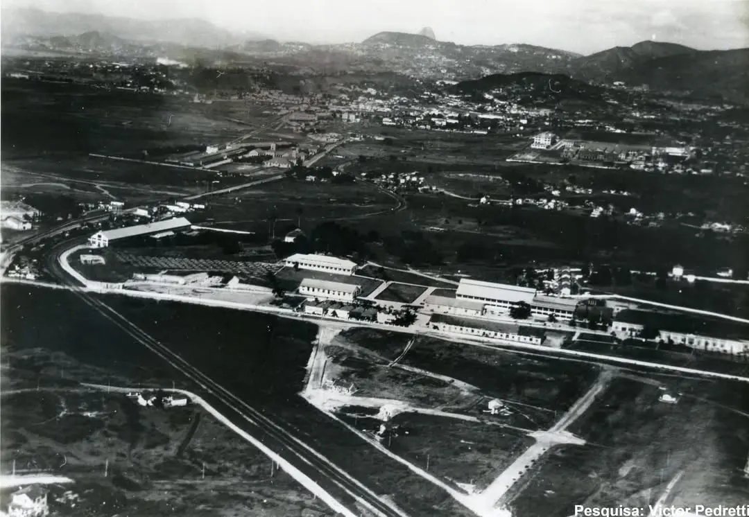 Área urbana com construção industrial e áreas verdes.