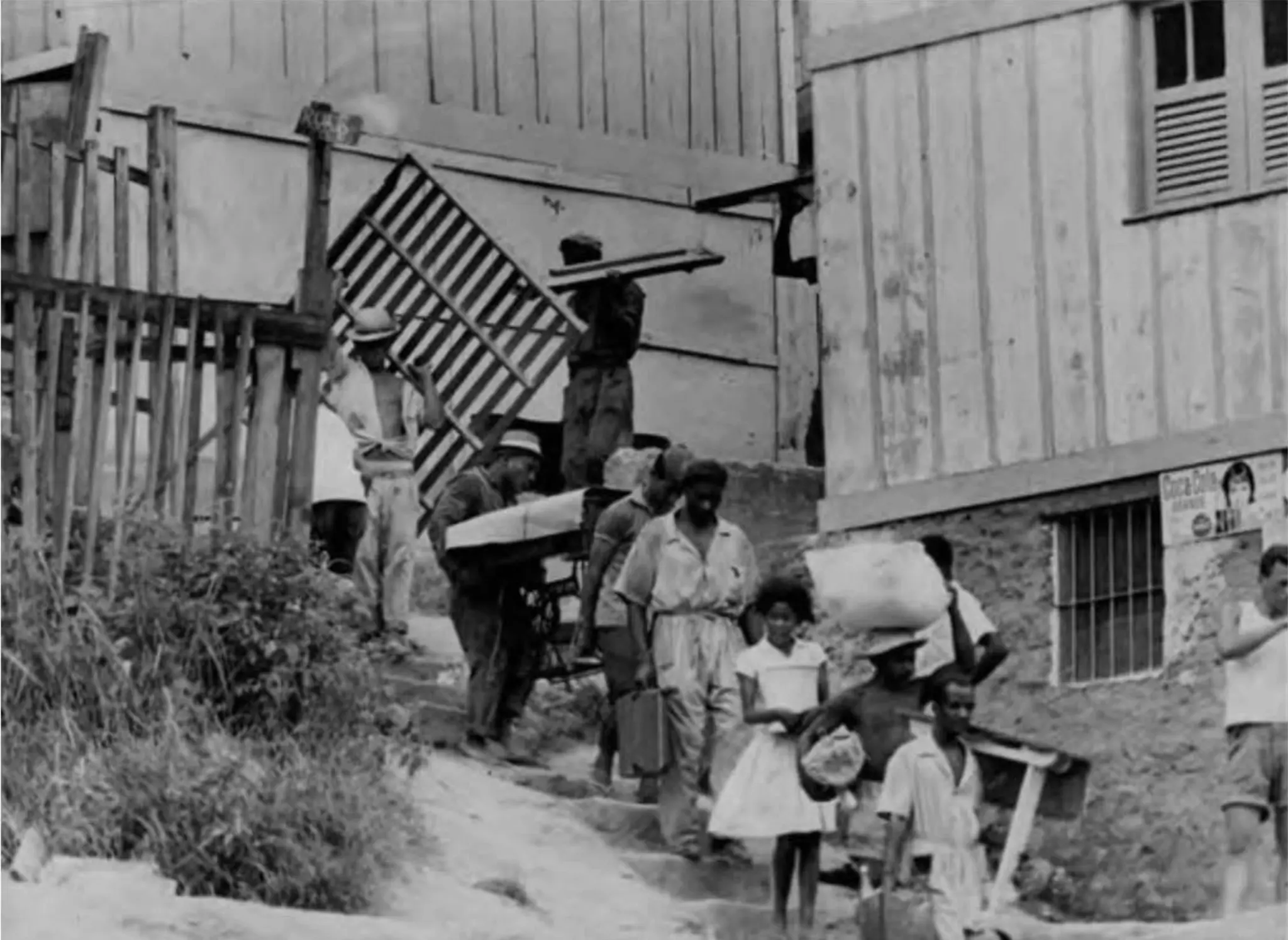 Grupo urbano em preto e branco, pessoas caminhando e construções ao fundo.