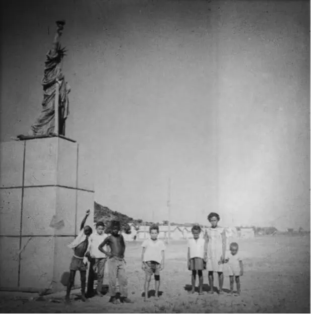 Crianças posam junto à réplica da Estátua da Liberdade.