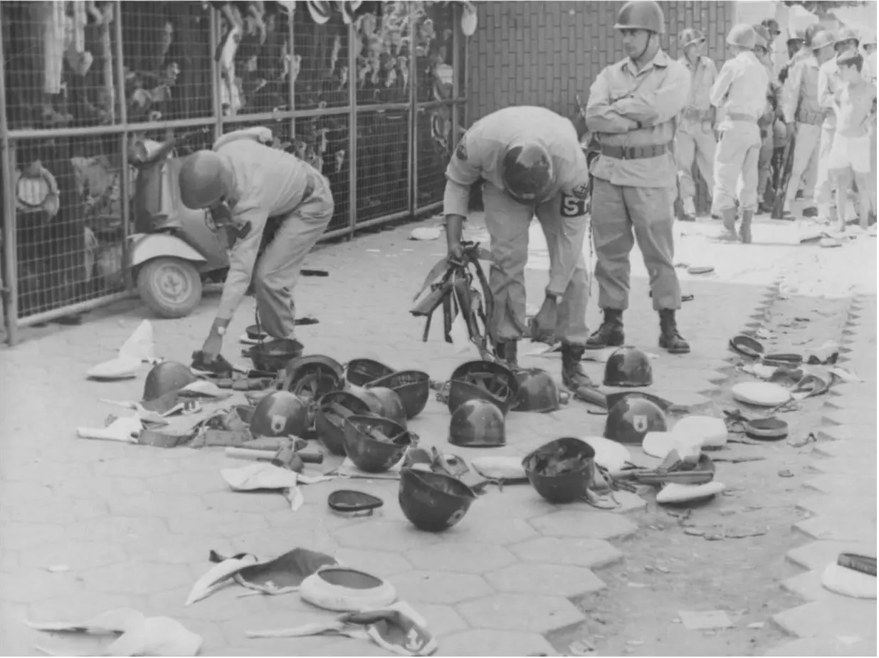 Grupo militar organizando equipamentos, foco em capacetes de fuzileiros navais.