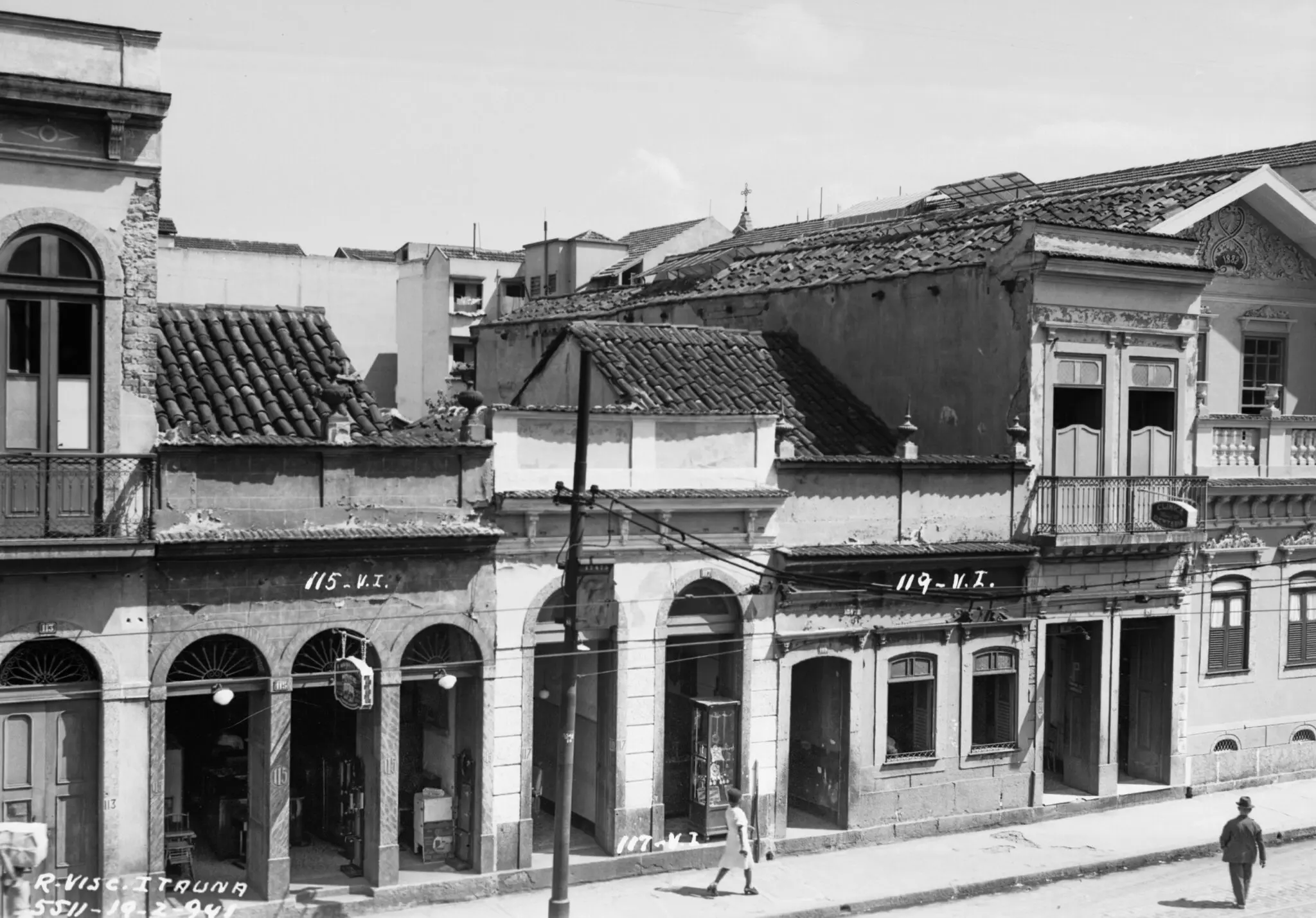 Uma rua com construções antigas em preto e branco.
