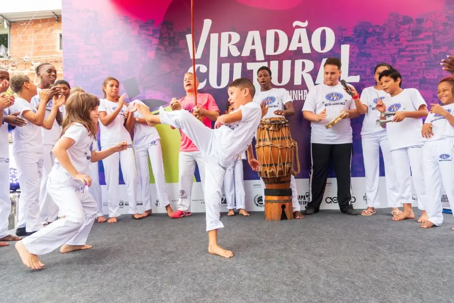 Menino praticando capoeira em evento cultural na Rocinha.