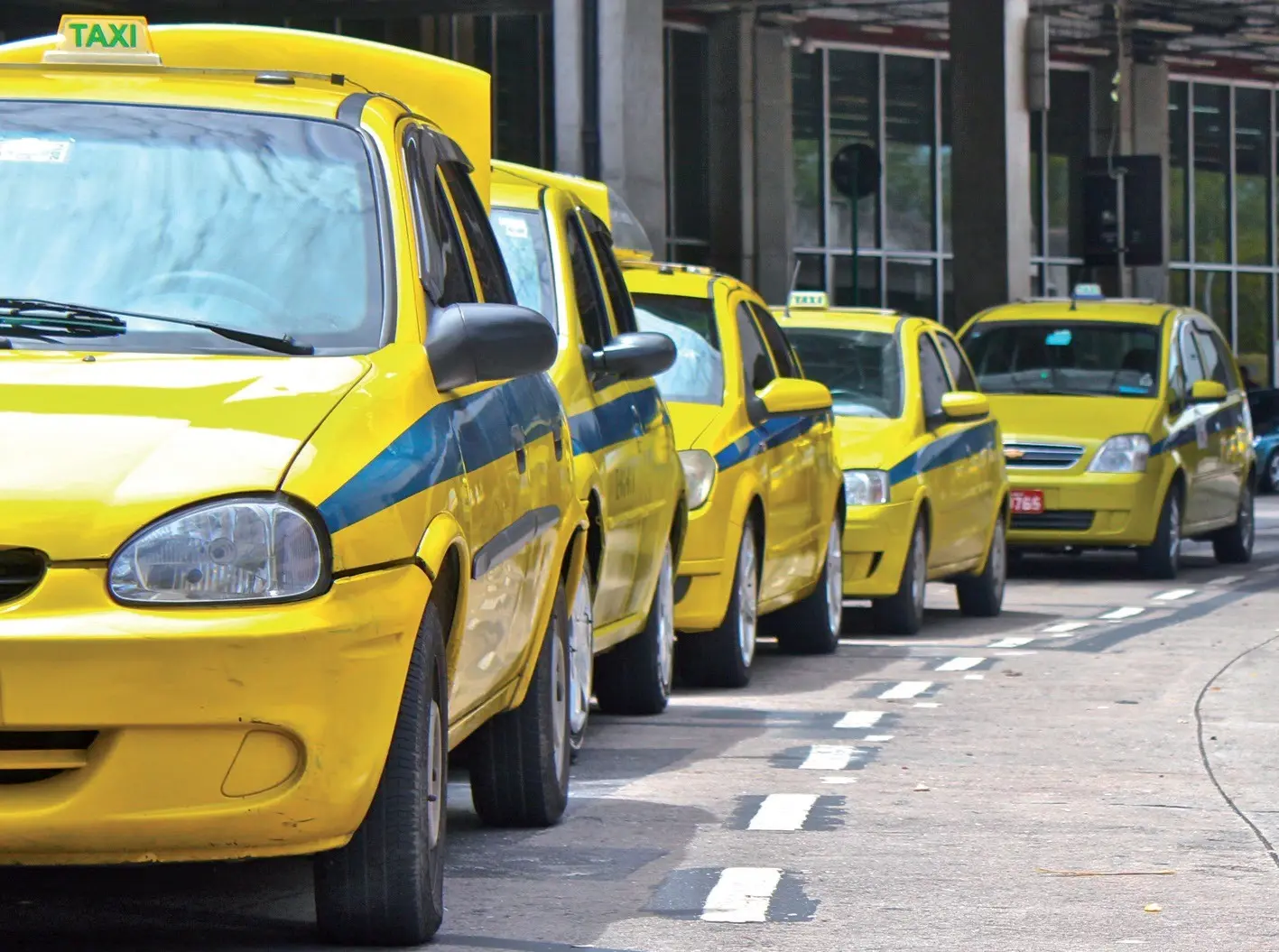 Fotografia de táxis amarelos em fila.