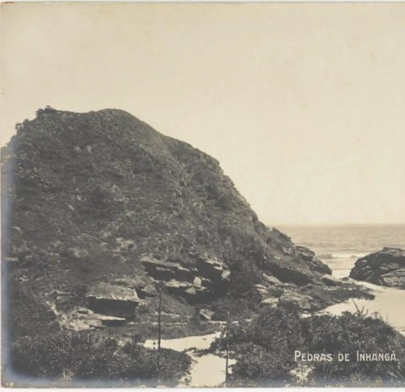 Paisagem costeira com rochas íngremes e horizonte marinho.