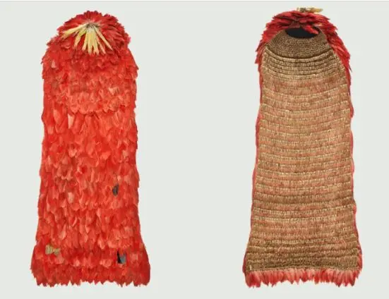 Duas peças de vestimenta tradicional tupinambá, um manto de penas vermelhas e outro de fibras naturais com faixa vermelha.