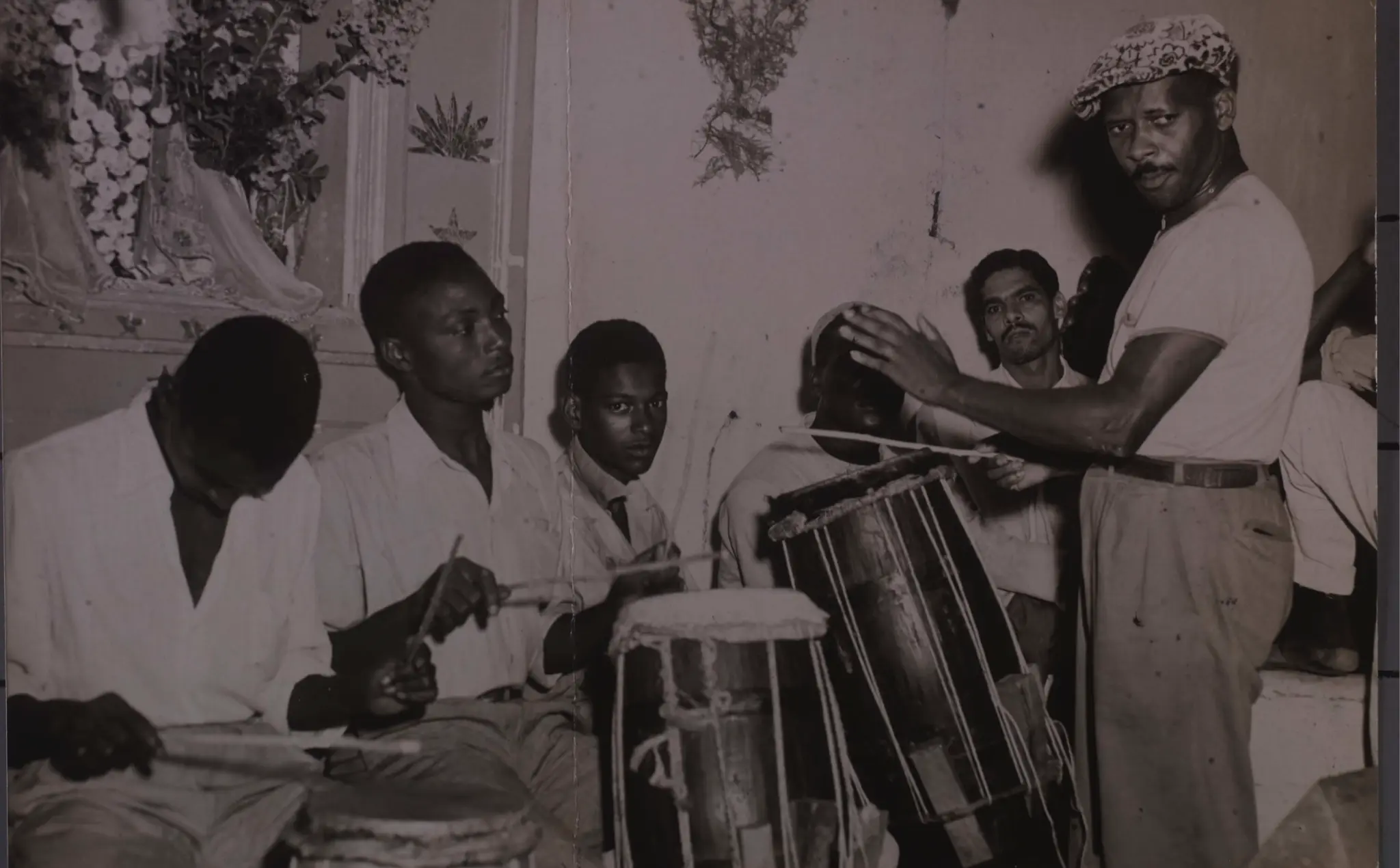 Grupo de músicos tradicionais africanos em ambiente interno.