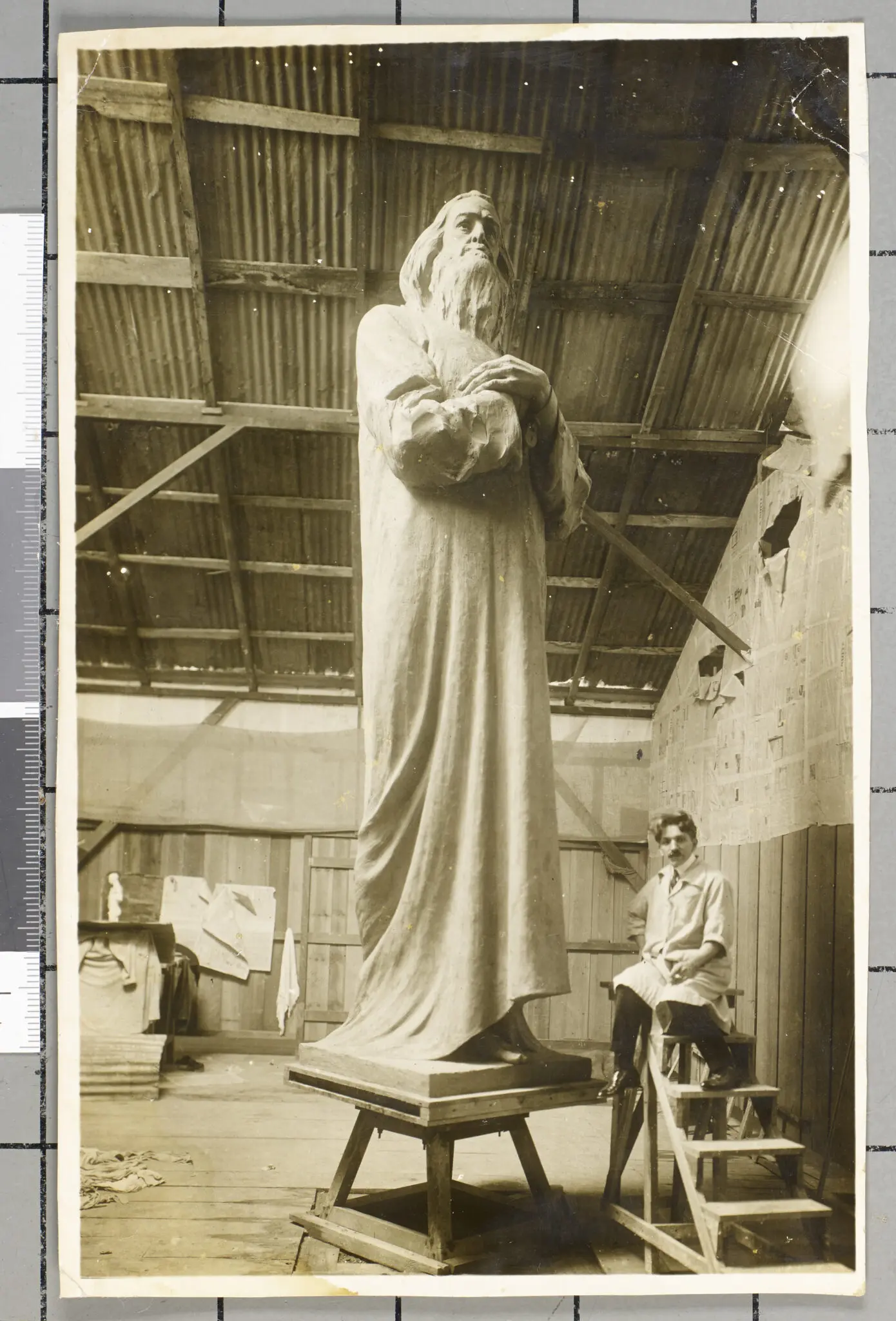Monumento escultural antigo em preto e branco, figura masculina com barba longa.