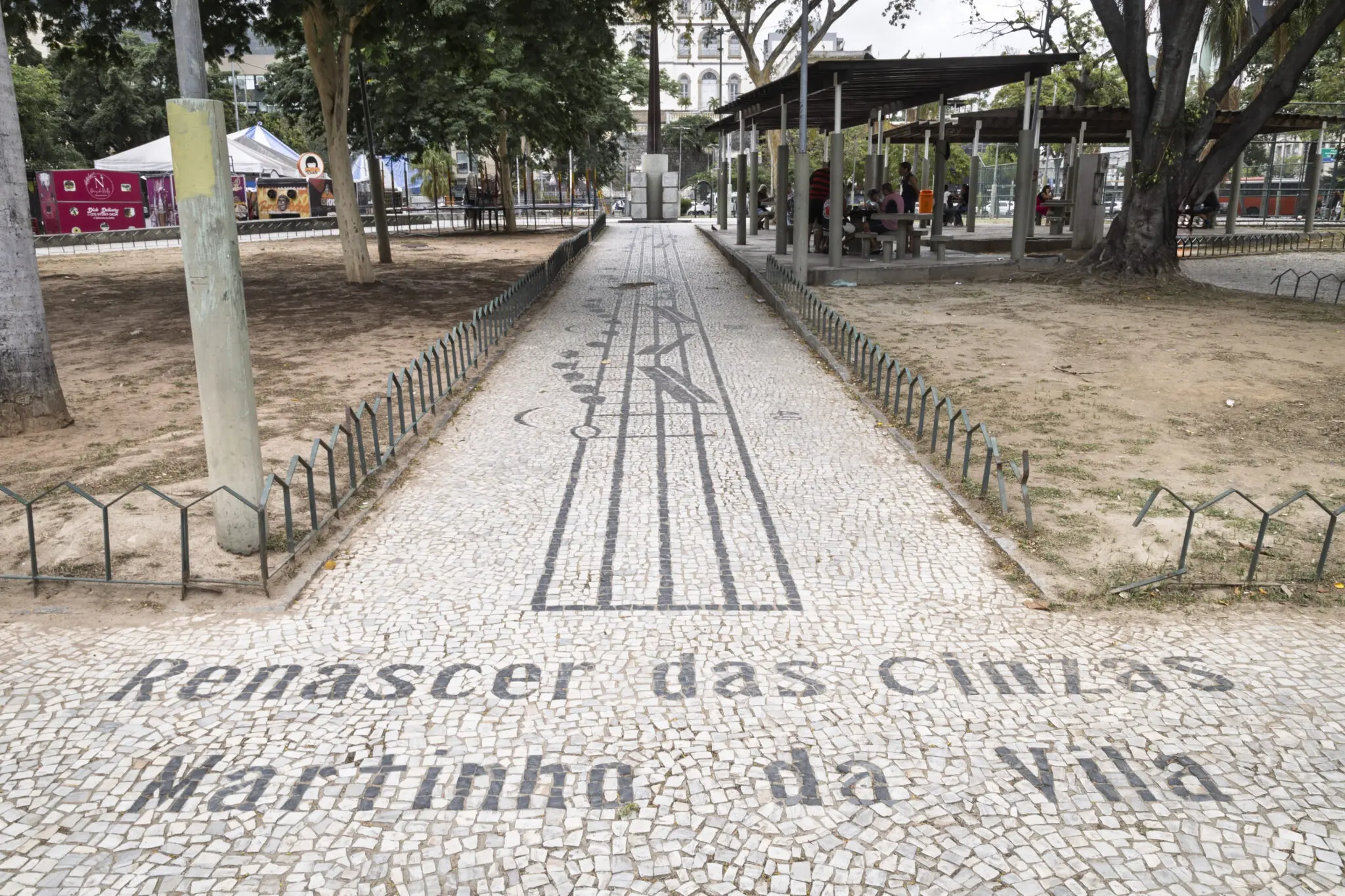 Calçada musical em parque com padrão geométrico e inscrição "Renacer das Cinhas Martinho da Vila".