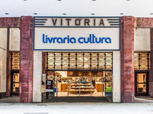 Fachada de Livraria Cultura Vitória com colunas de mármore vermelho e sinal luminoso azul.