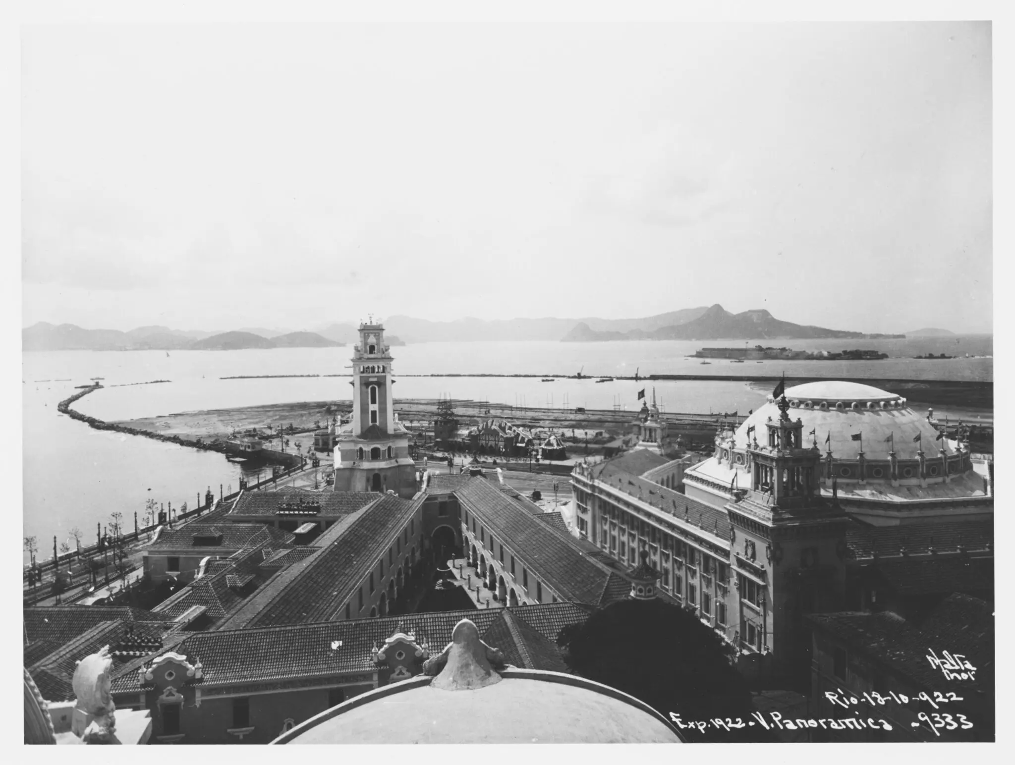 Cidade costeira histórica com edifícios e mar calmo.