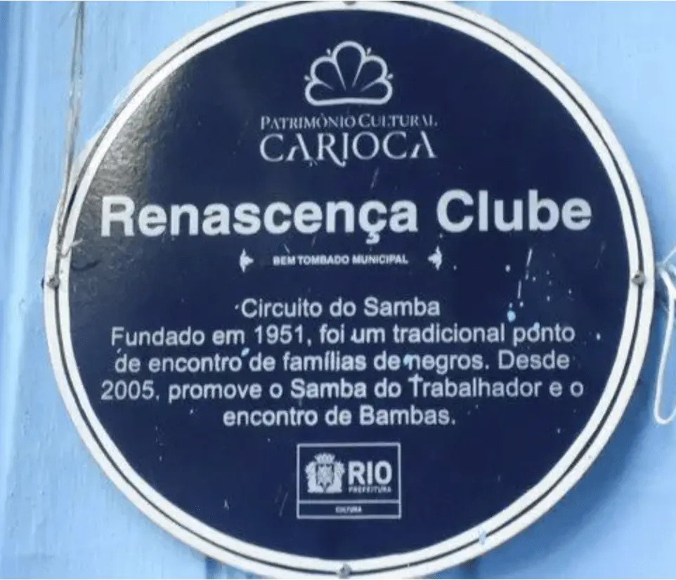 Placa azul com logotipo e texto sobre o Renascença Clube, bem tombado municipal.