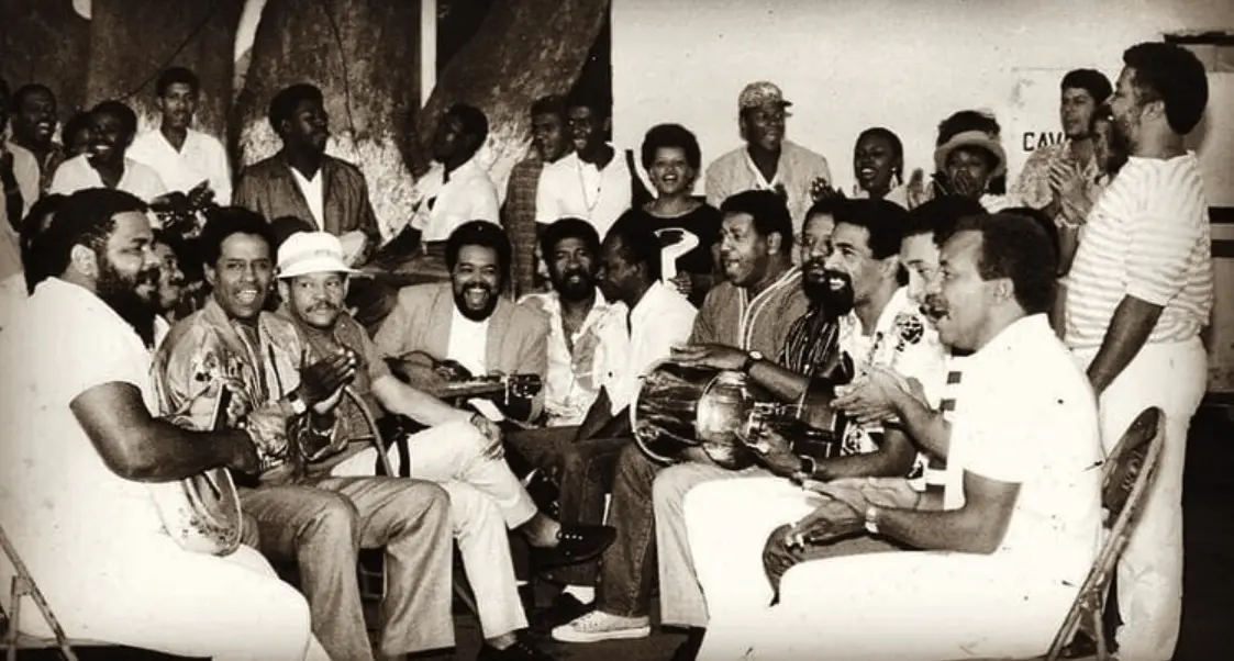 Grupo de músicos tocando em ambiente interno.