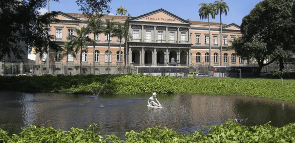 Edifício histórico Arquivo Nacional com jardim e árvores.