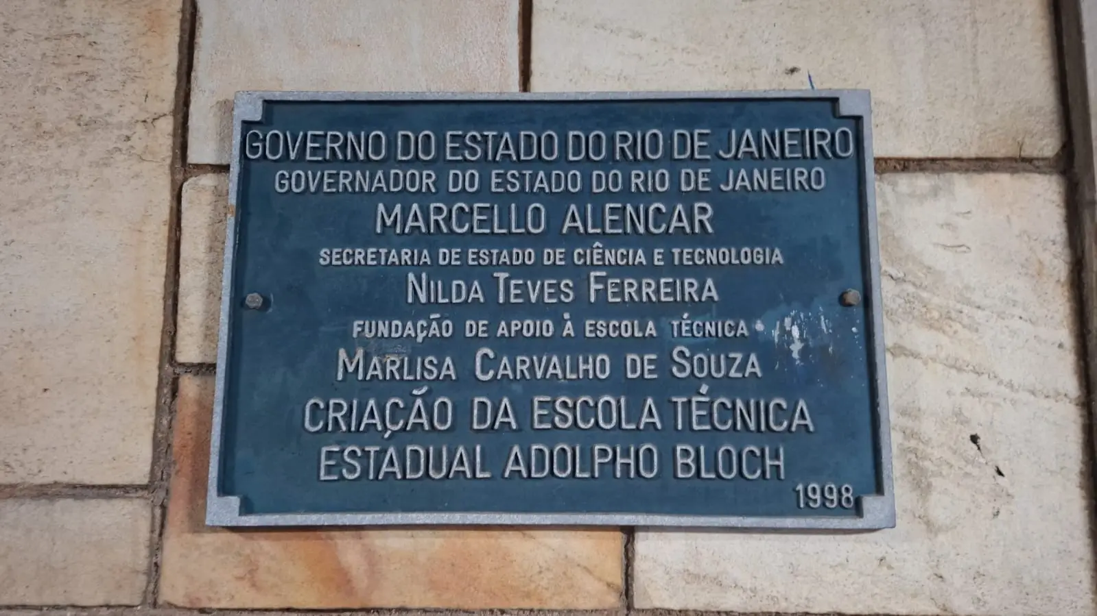 Placa comemorativa azul com texto sobre governo do Rio de Janeiro e escola técnica.