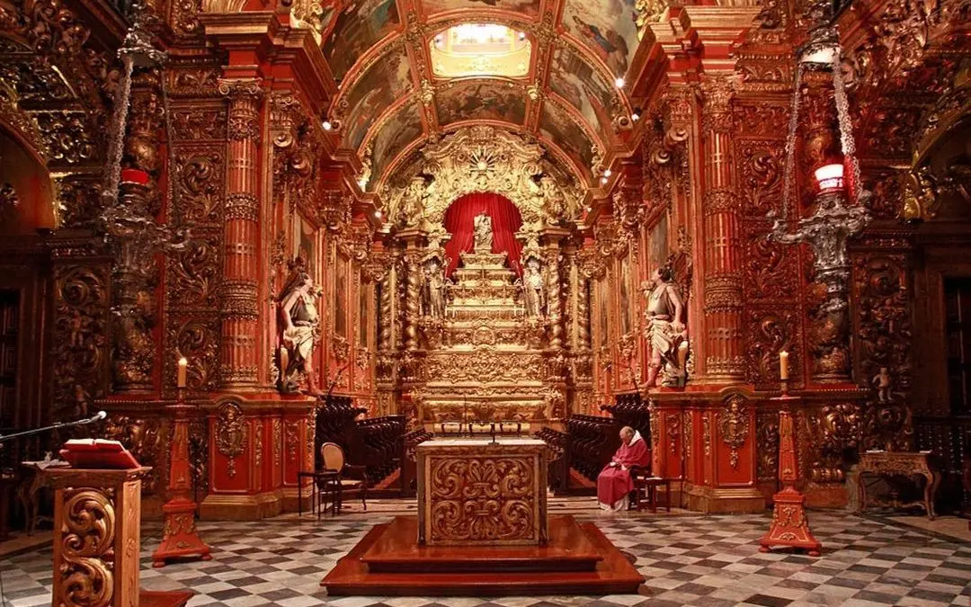 Interior de igreja com altar ornamental e detalhes em dourado.