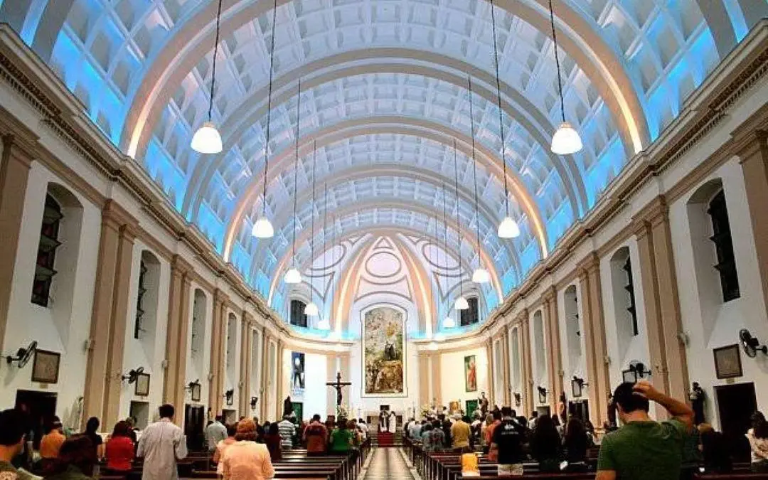 Interior clássico de igreja com arco-íris no teto.