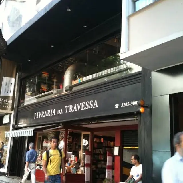Livraria "Livraria da Travessa" com pessoas caminhando e paradas em frente ao prédio preto e marrom.