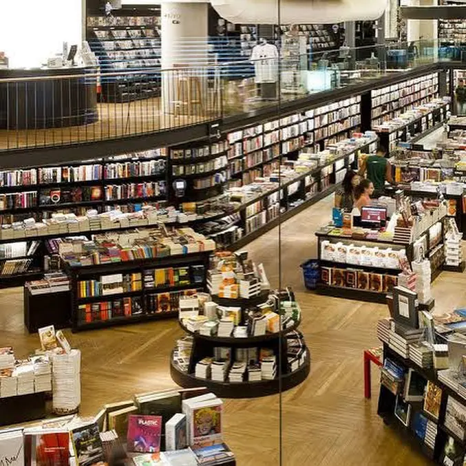 Livraria da Travessa: prateleiras cheias de livros, balcão de caixa e piso de madeira.