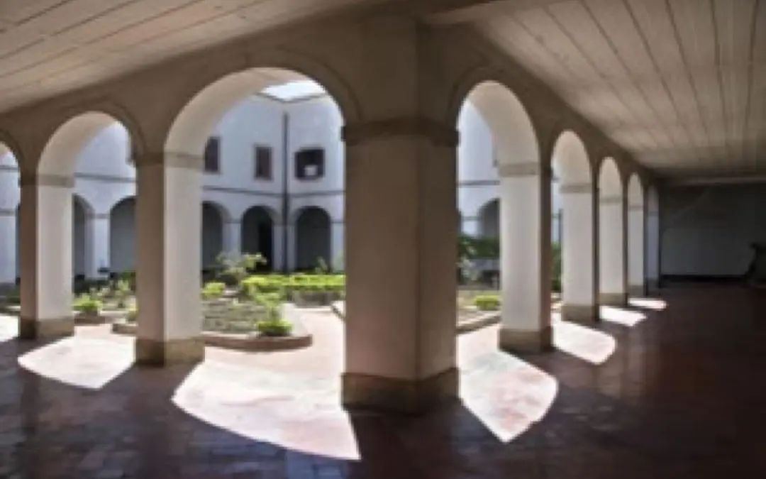 Corredor com arcos e colunas em convento.