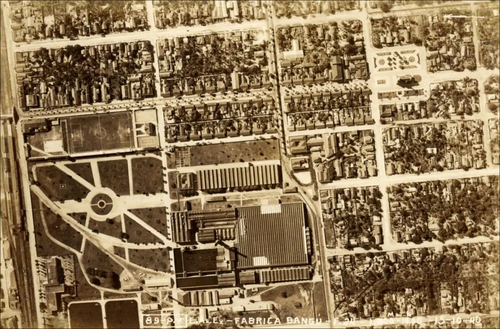 Cartão-postal urbano em sepia, mostrando edifícios e áreas verdes.