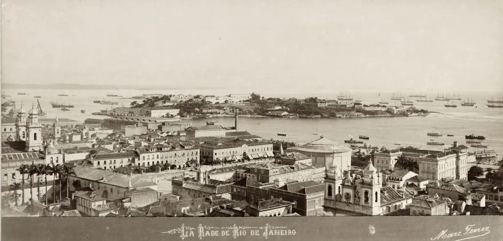 Vista panorâmica de edifícios históricos e navios em Rio de Janeiro.