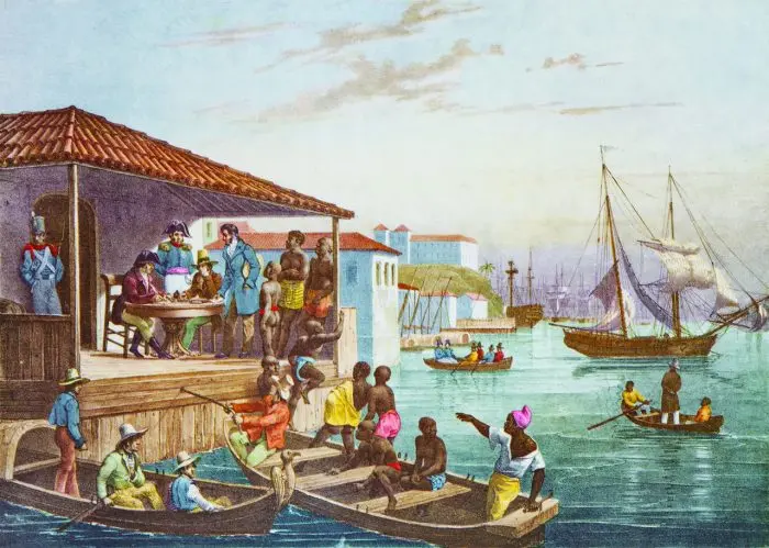 Pintura portuária com construção azul-vermelha, pessoas reunidas em mesa, barcos de madeira, navios atracados e fortaleza ao fundo.