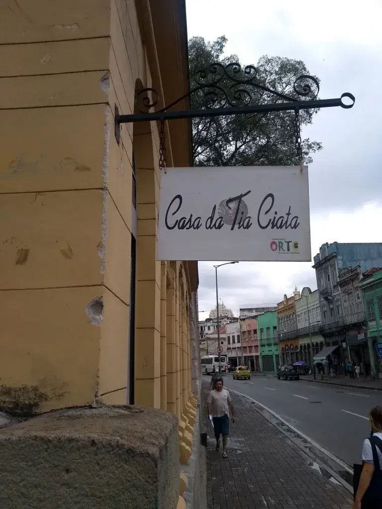 Uma rua urbana com prédios antigos e pessoas caminhando.